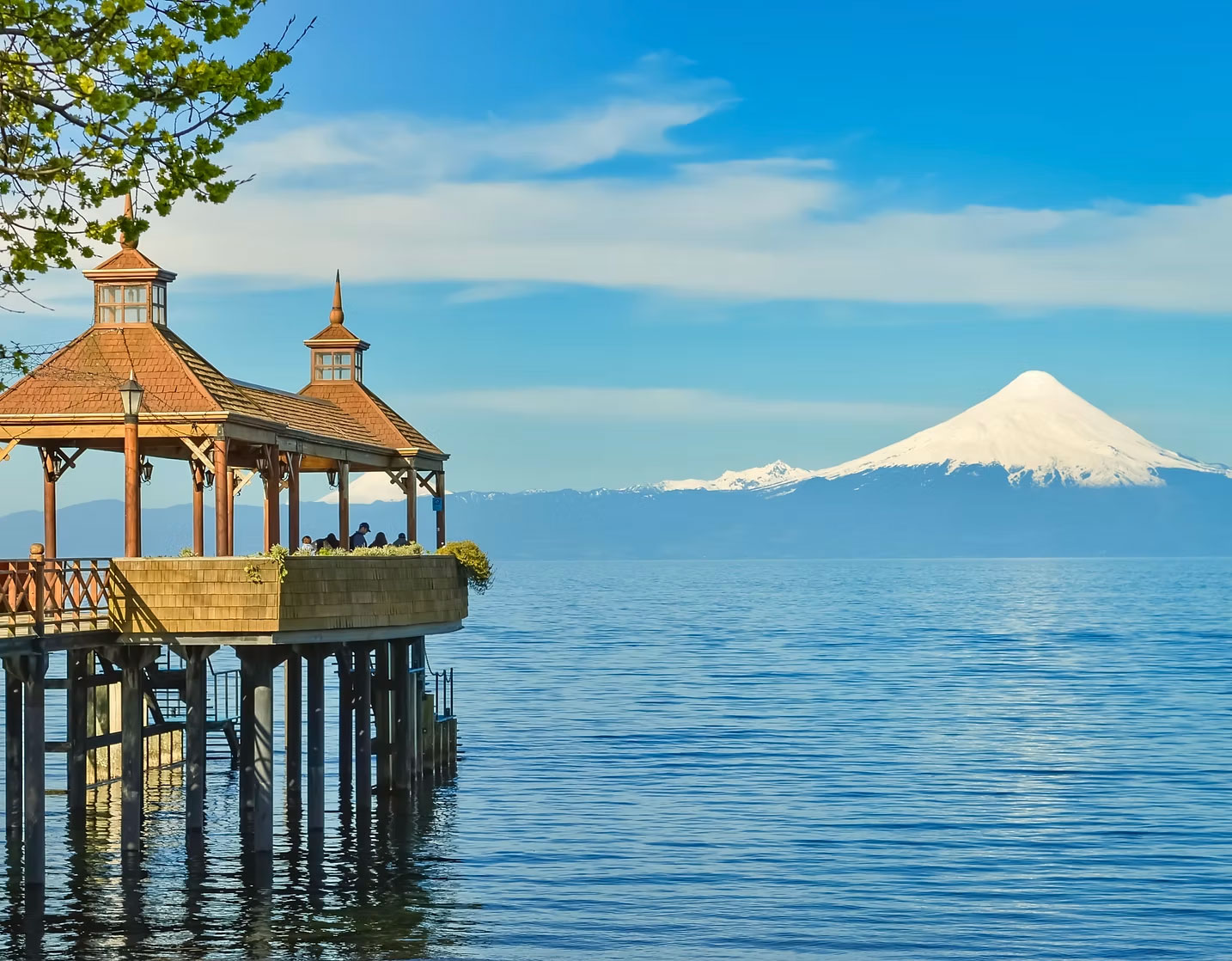 Glorieta de madera del Teatro del Lago sobre el lago Llanquihue con el volcán Osorno nevado al fondo